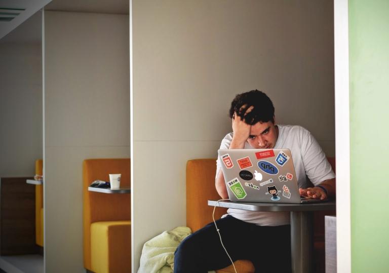 Person looking stressed at their laptop