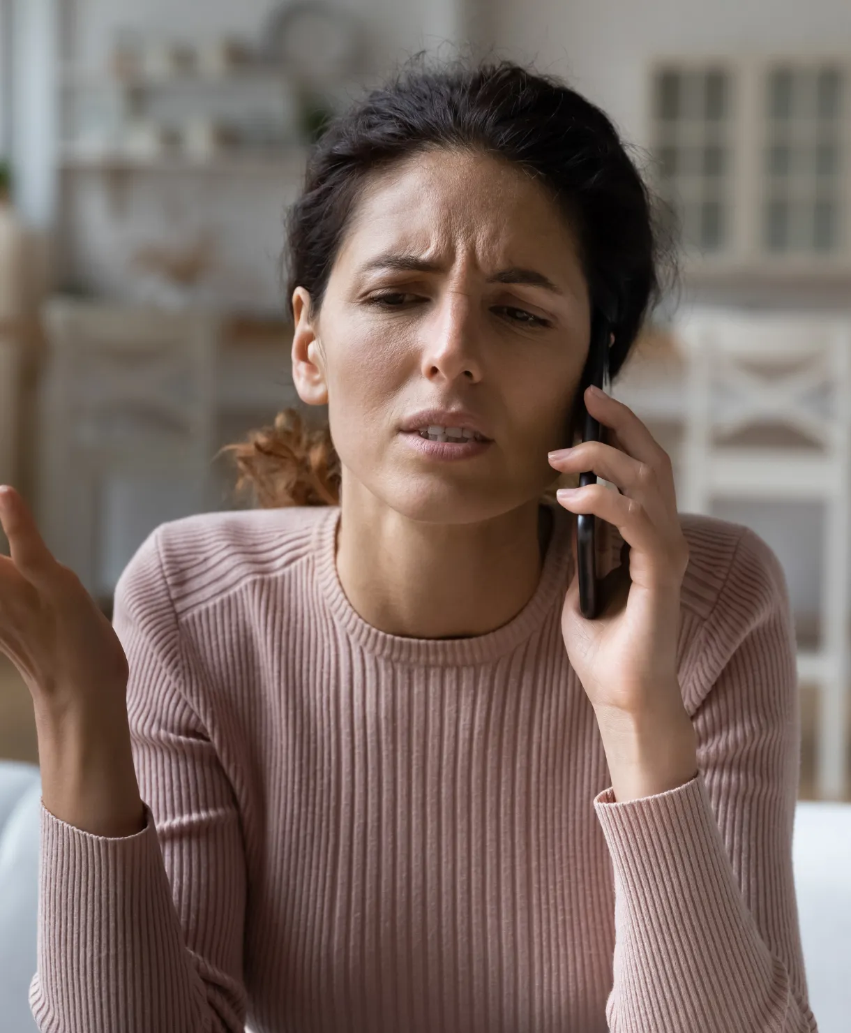Woman talking on the phone looking frustrated
